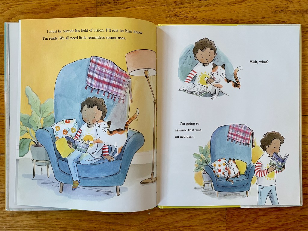 The boy reading in an armchair, cat interrupts and the boy moves him off and walks away. The cat pretends to not be offended.