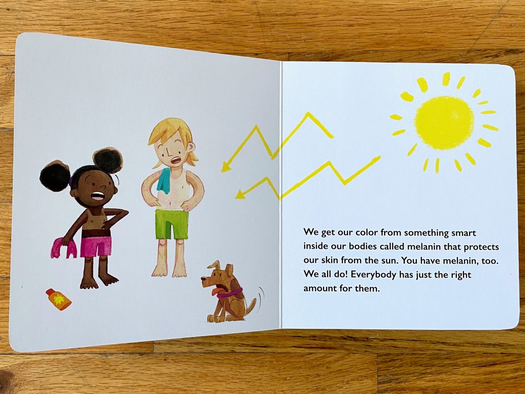 White spread with a black girl in pink shorts holding her tank top and pointing to her uncovered chest that is a lighter color brown than the rest of her body. And a white child next to her in green shorts with their teal top over their shoulder and pointing to their lighter skin from under their top. A dog looks on in surprise and a sun brightly shines on them from the opposite page with yellow arrows zigzagging the rays to their bodies.
