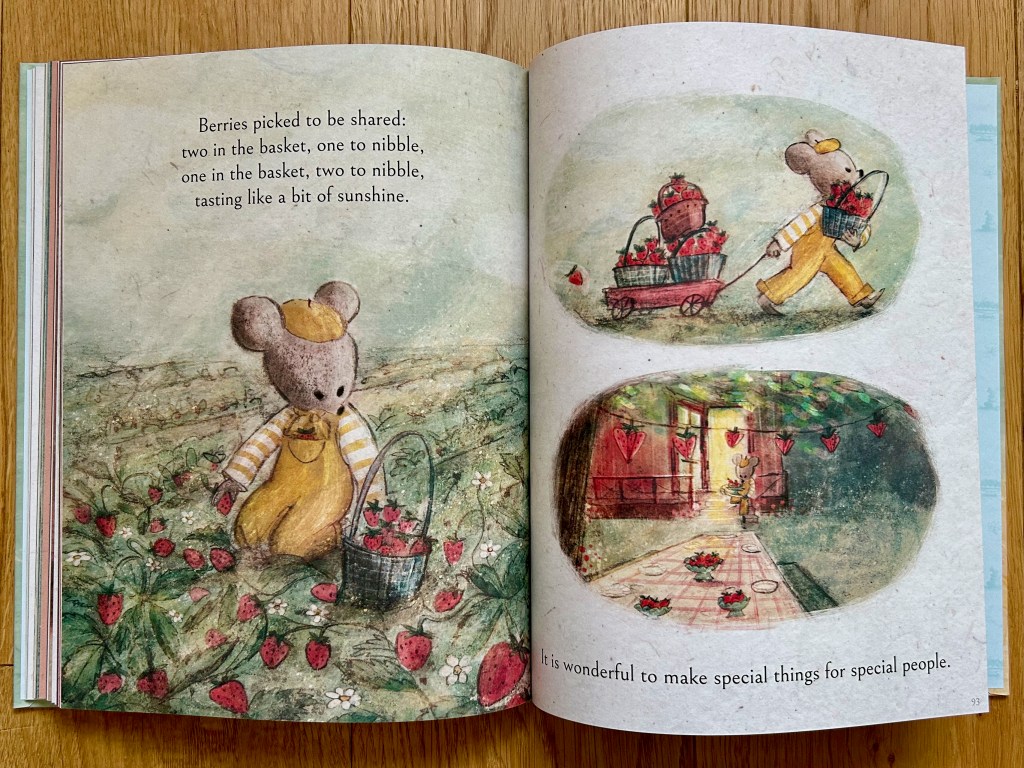 The little bear picks strawberries in a big field on the left page. The right page has two vignettes of the bear pulling a wagon of baskets of strawberries and then laying a table outside with strawberry bowls and hanging a strawberry banner.